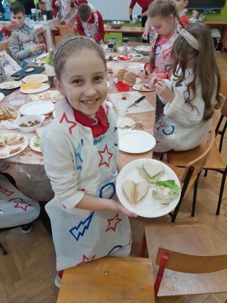 Dzieci pokazują zrobione prze siebie kanapki