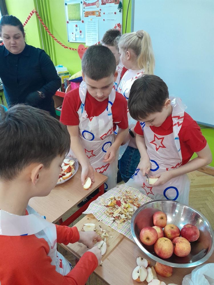 Dzieci obierają marchew i jabłka