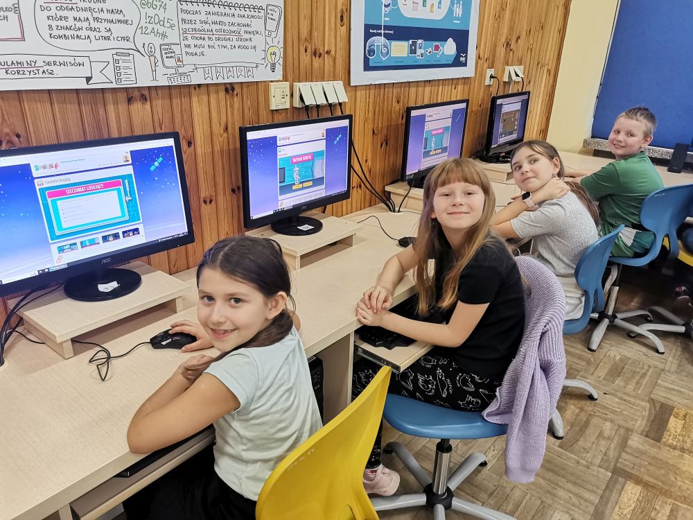 Uczniowie siedzący przy komputerach.