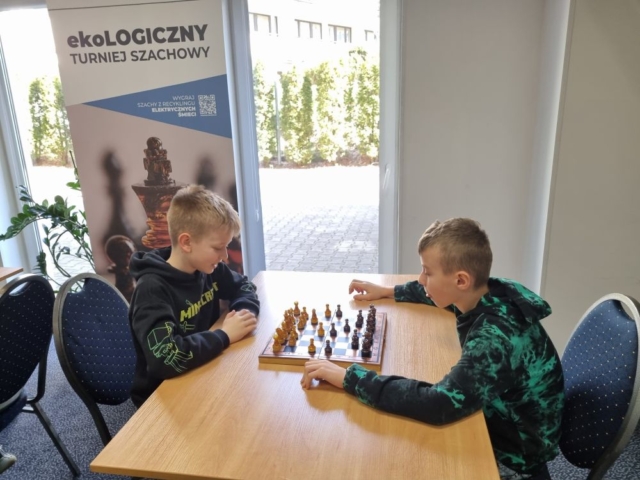 Dwóch uczniów siedzi przy stole i gra w szachy