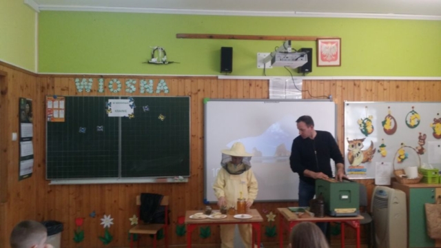 Zbigniew Kuśmierek oraz dzieci z kl. 3b, w trakcie zajęć na temat pszczelarstwa.