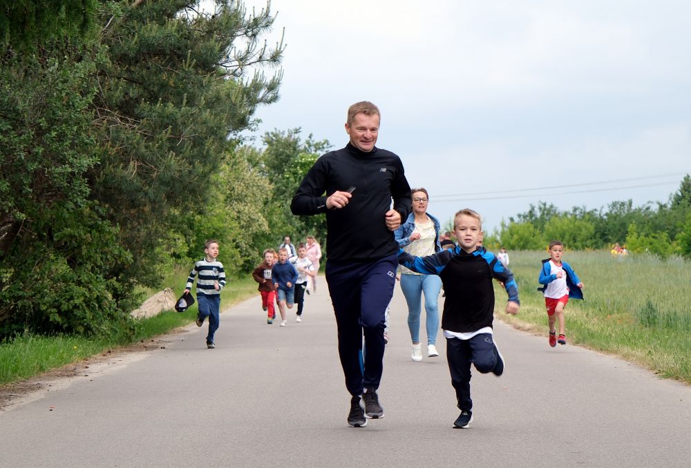 Dzieci biegną wraz ze swoimi rodzicami