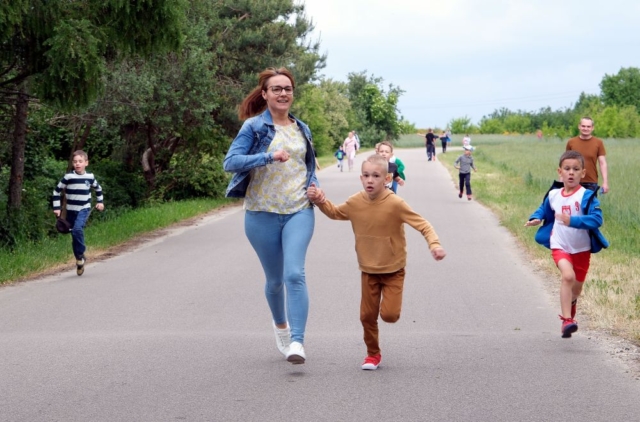 Dzieci biegną wraz ze swoimi rodzicami