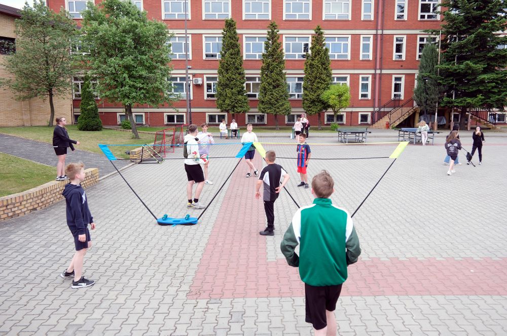 Uczniowie grają w babingtona na boisku szkolnym