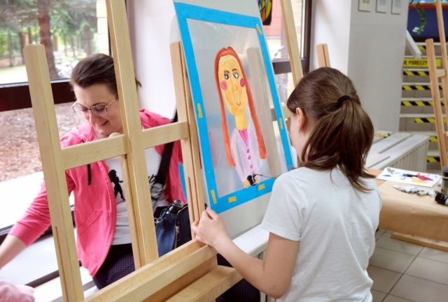 Dziewczynka maluje portret mamy