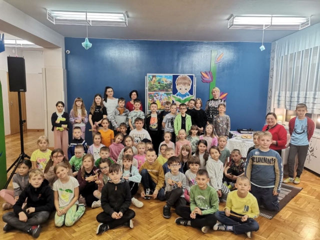 Pamiątkowe zdjęcie - dzieci stoją w licznej grupie z wychowawcami klas drugich i z zaproszonym gościem - z Panią Danutą Gronczyńską.