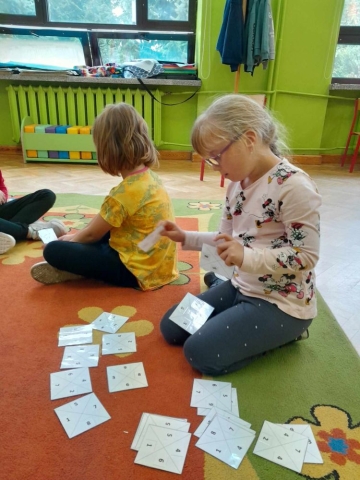dzieci układają domino z cyframi oraz kolorami