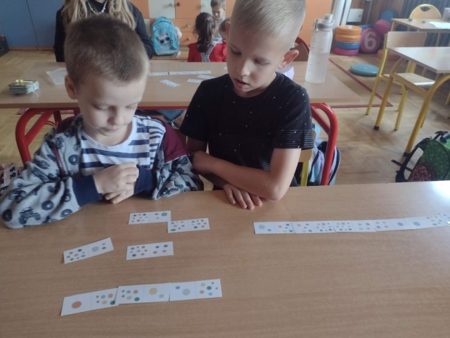 Chłopcy układają domino matematyczne