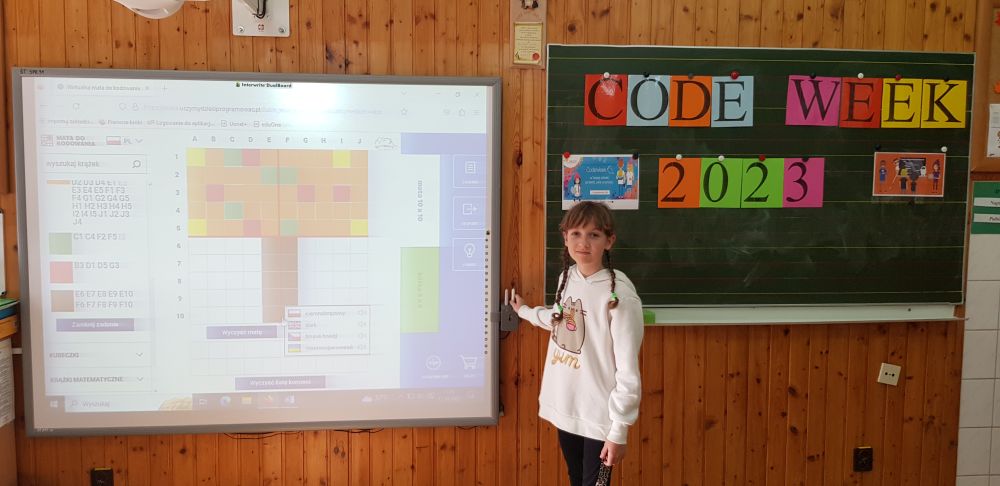 Uczennica stoi przy tablicy interaktywnej