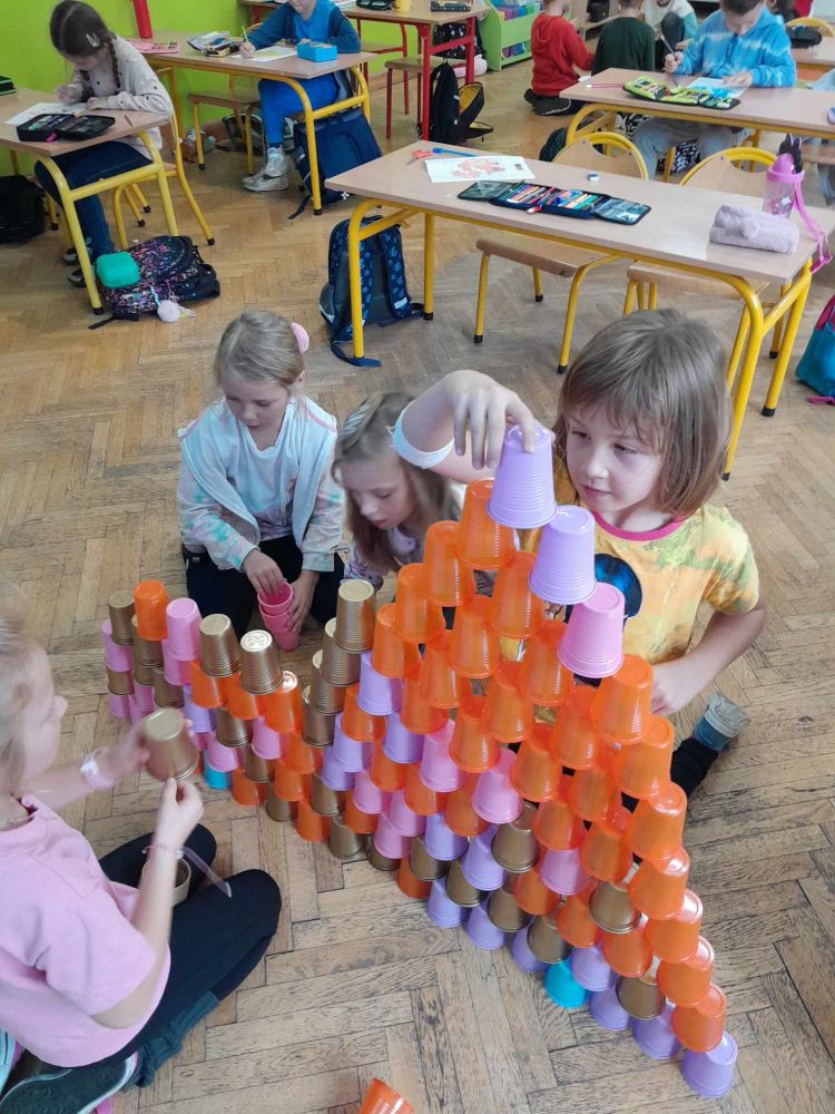 dzieci układają wieżę z plastykowych kubków