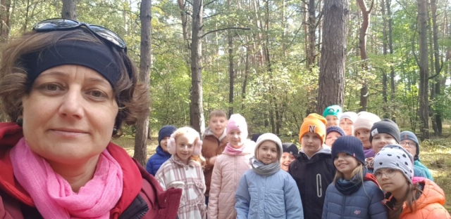 Uczniowie stoją w grupie w lesie