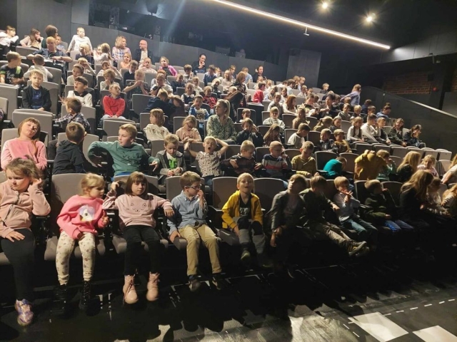 Uczniowie siedzący na krzesłach na widowni teatru Pinokio w Łodzi w oczekiwaniu na spektakl