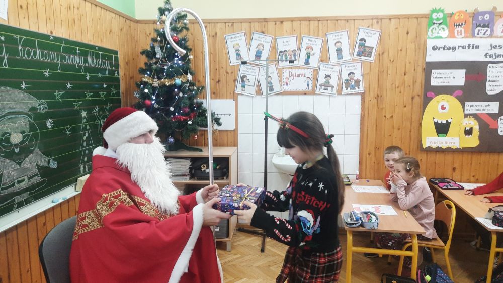 Mikołaj daje dziewczynce prezent