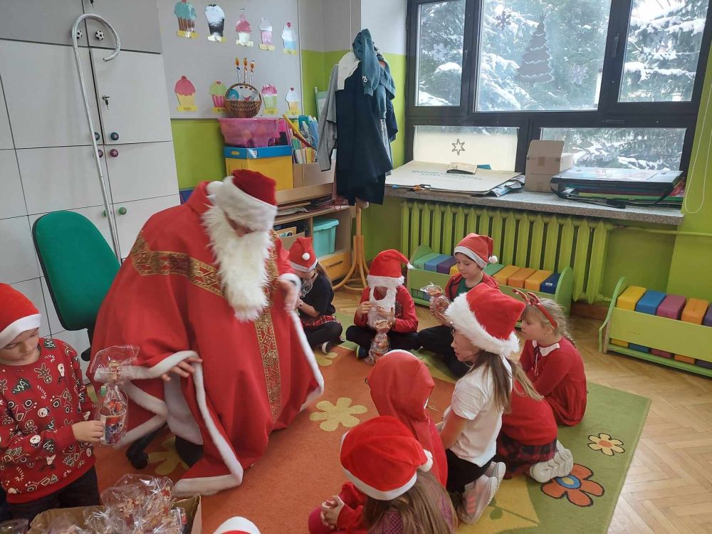 Dzieci siedzą przy Mikołaju