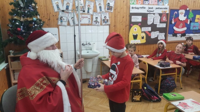Święty Mikołaj daje chłopcu prezent