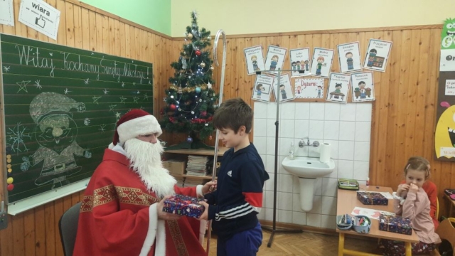 chłopiec odbiera prezent od Świętego Mikołaja
