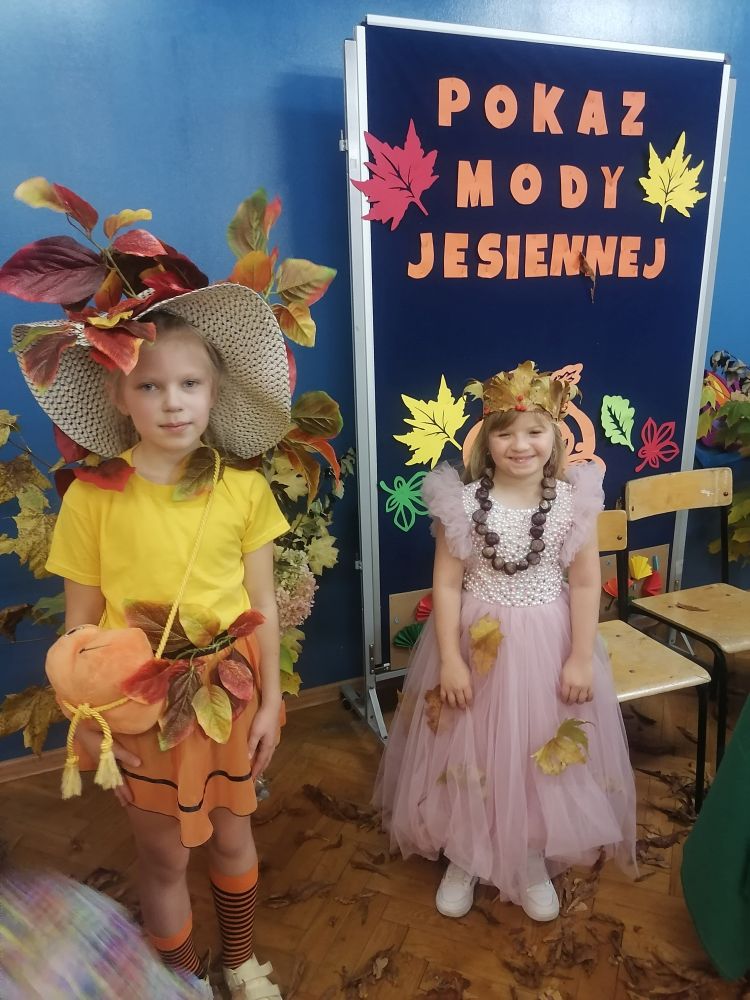 Dwie dziewczynki pozują w strojach inspirowanych jesienią.