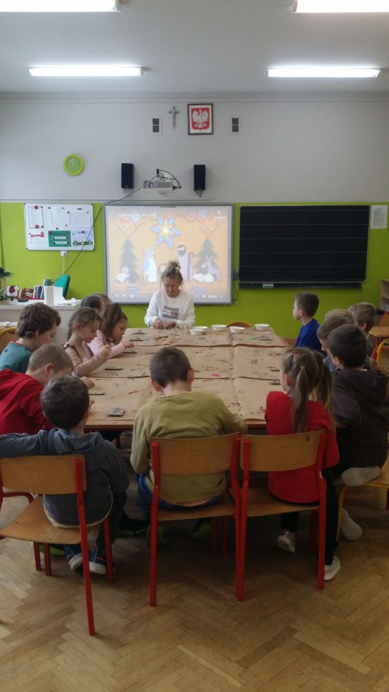 Uczniowie pracują w klasie przy stolikach tworząc zawieszki sojowe