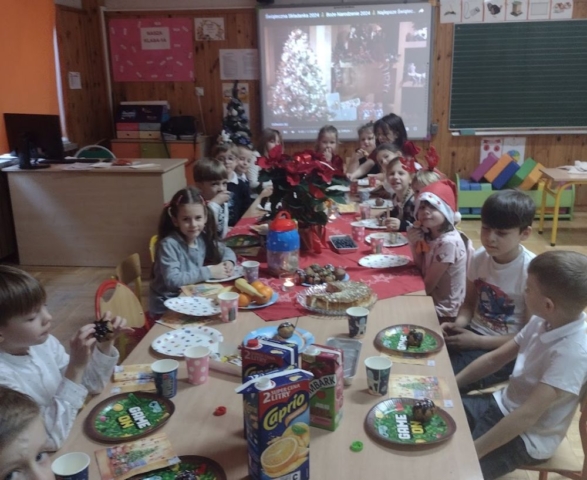 Dzieci siedzą przy klasowym wigilijnym stole