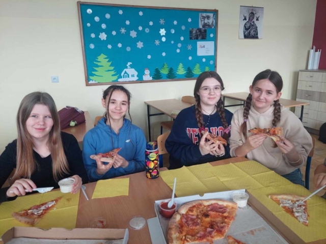 Uczniowie jedzą pizzę - nagrodę w konkursie