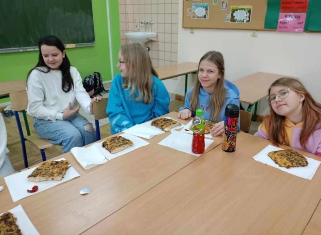 Uczniowie jedzą pizzę - nagrodę w konkursie