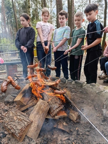 Uczniowie pieką kiełbaski przy ognisku